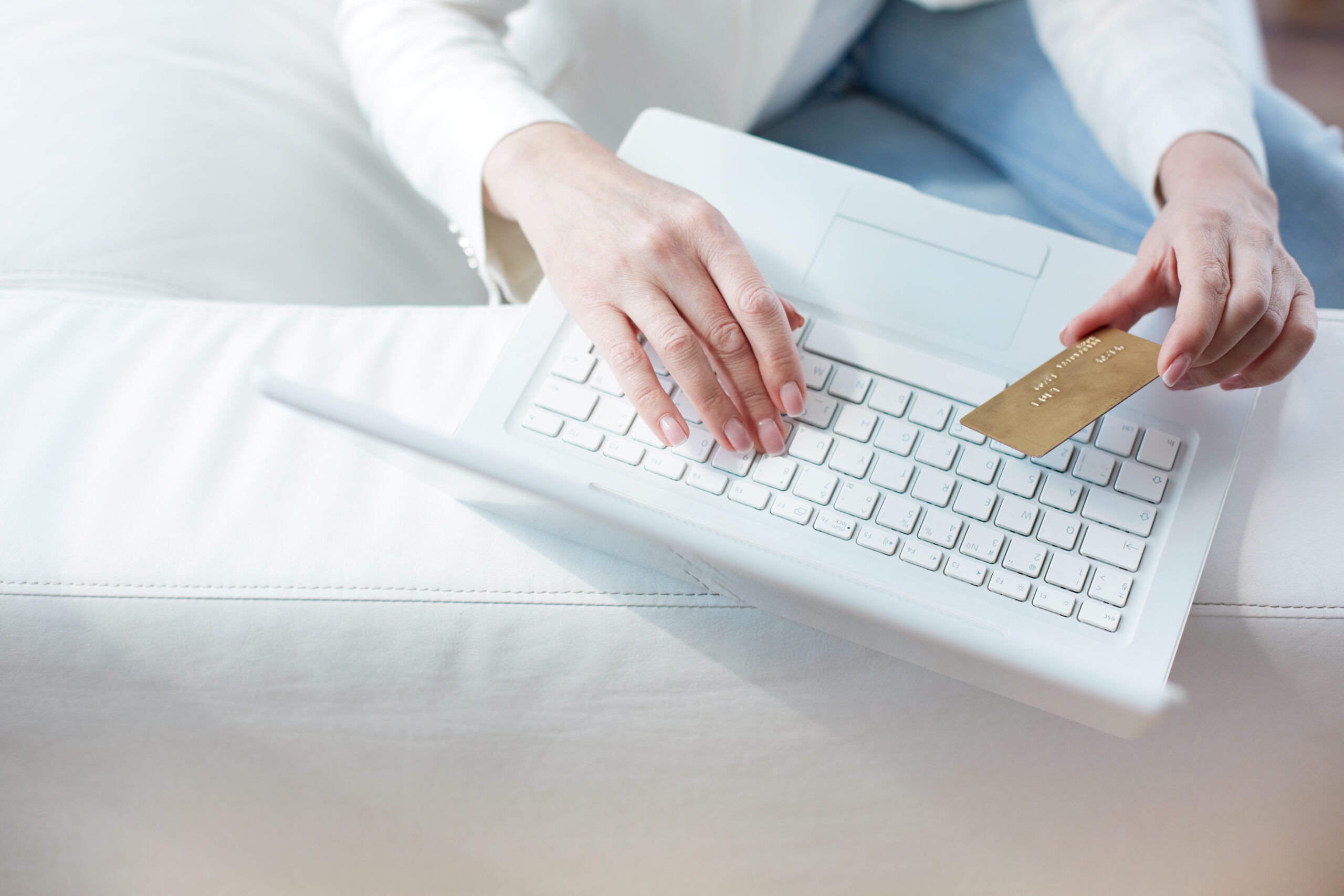 Hands with a bank card making an online payment on a laptop