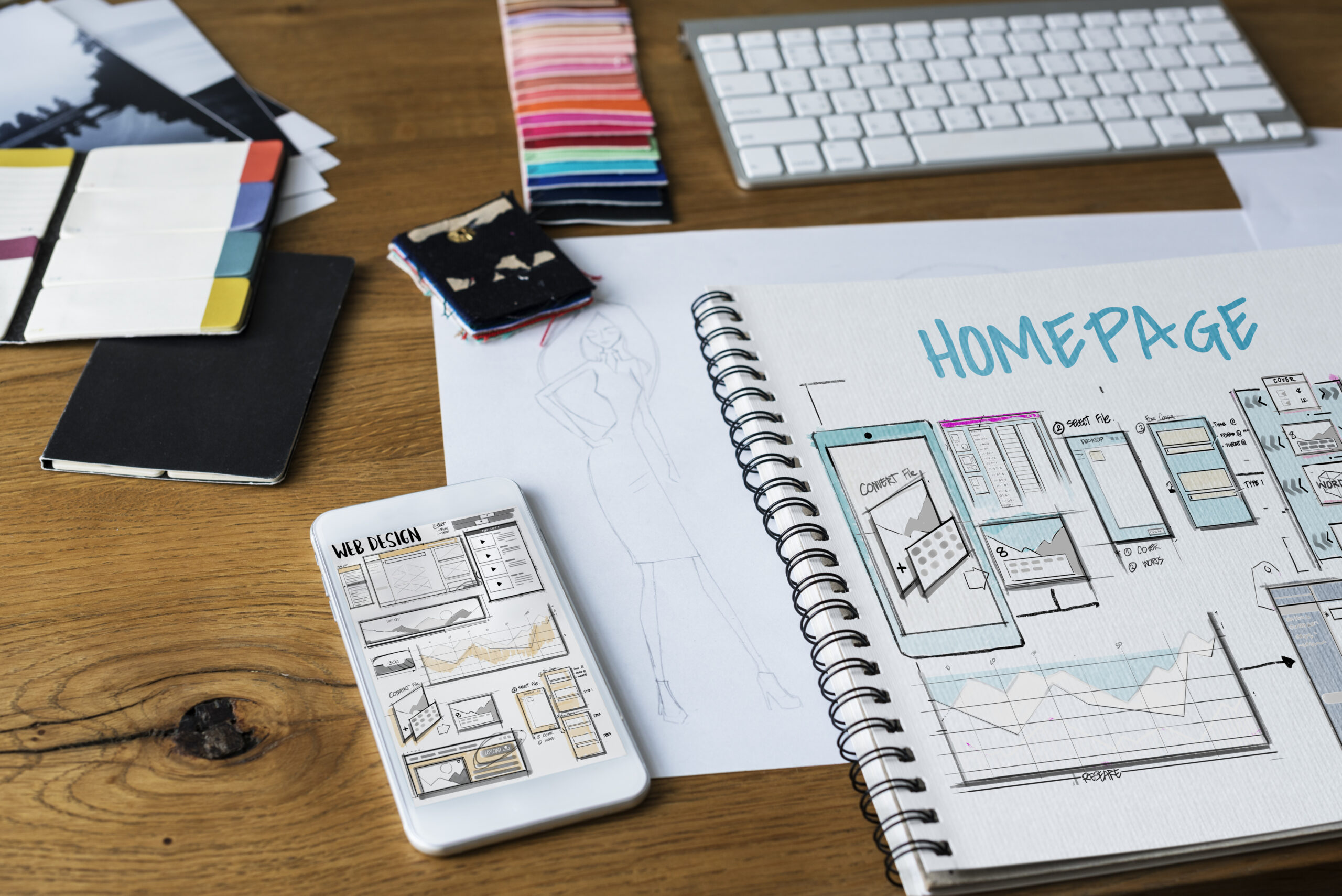 Block sketch of a home page layout, next to a phone and markers